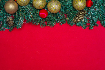 Ótimo fundo de natal vermelho com folhas verdes de pinheiro e objetos decorativos de celebração natalina
