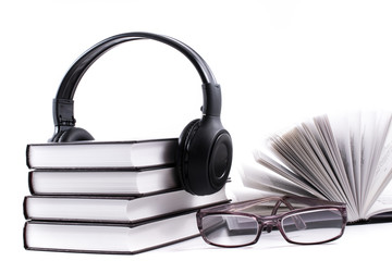 books with headphones and spectacles. Audio book concept