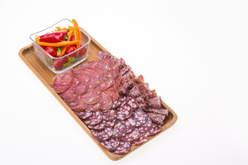 Set of meat delicatessen, tomatoes and peppers on a wooden table.