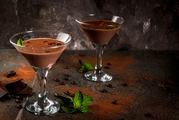Cream coffee cocktail, chocolate martini with mint on black stone table, copy space