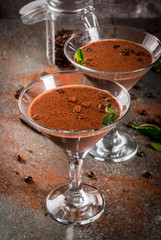 Cream coffee cocktail, chocolate martini with mint on black stone table, copy space
