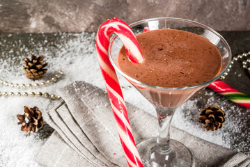 Christmas drinks, peppermint mocha martini cocktail with candy cane, on grey background copy space