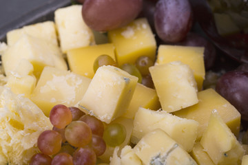 Set of cheeses and grapes on a black background