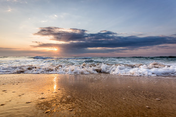Dramatic sunrise in front of sea full with waves