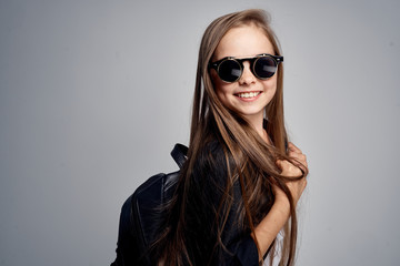 little girl in sunglasses with a backpack, portrait