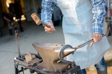 blacksmith working metal with hammer