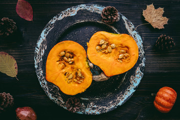 Ripe pumpkin on the wooden background, top view