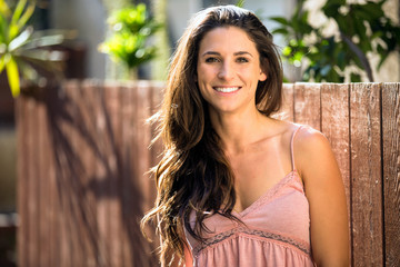 Beautiful commercial brunette model with perfect white teeth smile on warm sunny day