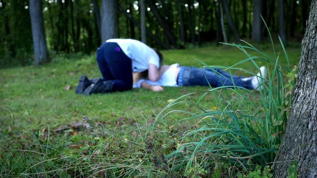 Zombie woman eating dead man in the woods