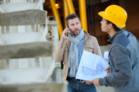 two male industrial engineers looking at techincal drawing plans