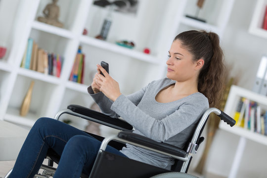 young woman in a wheelchair using mobile phone