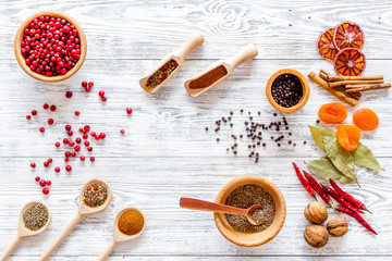 Kitchen table with spices and dry herbs on light wooden kitchen background top view pattern
