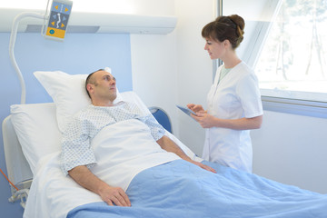 Obraz na płótnie Canvas man in hospital bed with the nurse