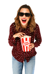 Young casual woman in glasses holding bucket with popcorn and laughing happily on white background.