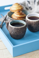 Breakfast in bed: two cups of tea, delicious and hot pastries. Daylight.