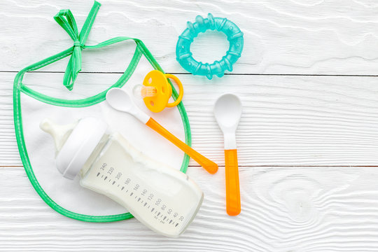 children feeding with breastmilk or infant formula powdered baby milk and toys on wooden background top view