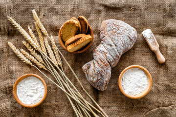 Obraz na płótnie Canvas bakery set with fresh wheaten bread on table rystic background top view