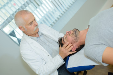 man receiving head massage from physiotherapist in clinic