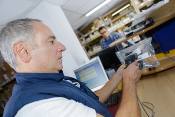 man working at desk in warehouse scanning barcode