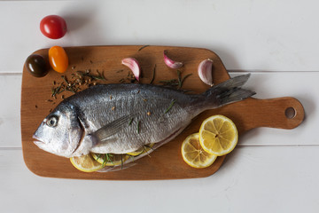 Mediterranean fish - dorado and vegetables on the chalkboard. top view