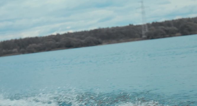 Attractive female wake boarding in a wakepark near a city. 4K UHD 60 FPS 