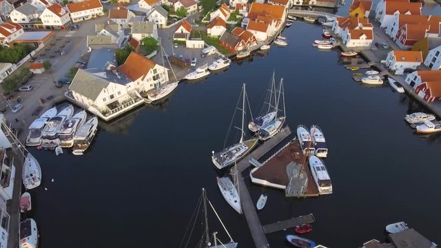 Flight by helicopter over European port city with a magnificent view of the bay and the house. Top view of amazing port city of Skudeneshavn, Norway. Beautiful view of the sea bay in summer at sunset