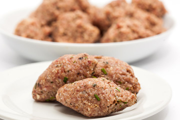 Step by step Levantine cuisine kibbeh preparation : Raw kibbeh balls on white dish