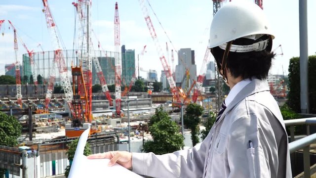 建設現場で図面を確認するビジネスマン　建築　設計　土木系