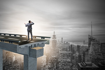 Businessman in uncertainty concept with broken bridge