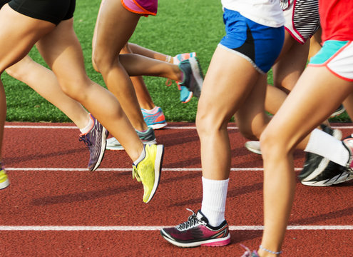 Legs of high school girls running on a track
