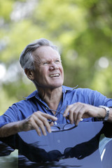 Man posing by an open car door