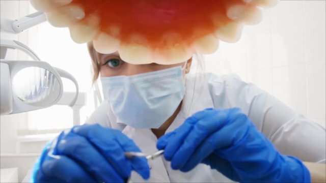 Female Dentist with Tools Checking Patient Teeth under Upper Jaw