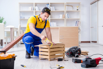 Repairman carpenter working sawing a wooden board with a hand sa