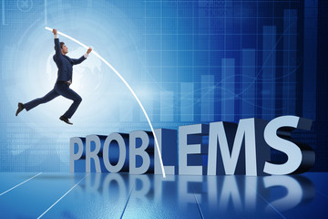 Businessman jumping over problems in business concept