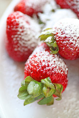 Fresh strawberries heavily dusted with powdered sugar closeup