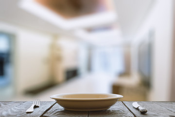 empty plate with fork and knife on wooden table