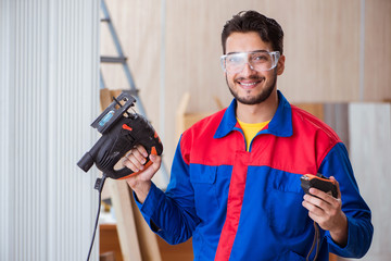 Young repairman working with a power saw sawing