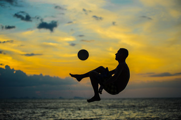 Kicking a ball. Silhouette of a man on a beach