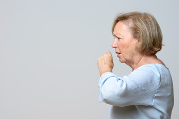 Distressed senior woman coughing