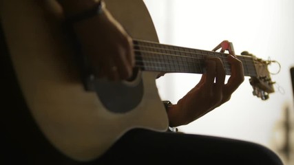 Rock artist playing acoustic guitar at concert in loft or conference hall