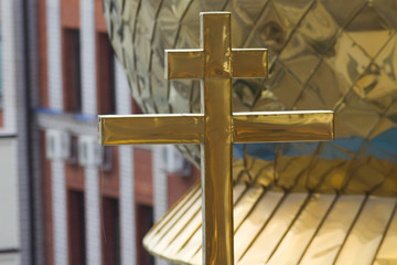 Fototapeta na wymiar Golden orthodox cross on dome of church
