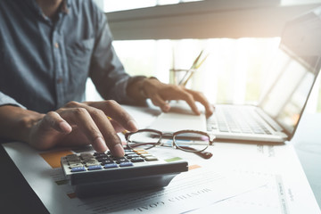 close up, business man or lawyer accountant working on accounts using a calculator and laptop...
