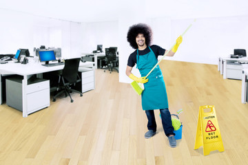 Male maid playing with broom in the office