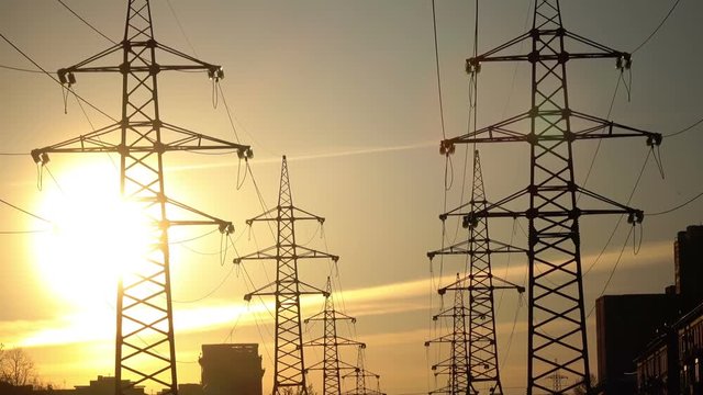 Electric support of high voltage power cables. Energy industry. Production, distribution and transmission of electricity. power lines. Power substation in the big city during sunset
