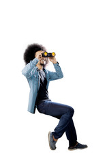 Afro student using a binocular on studio