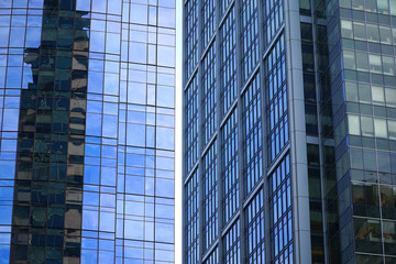 close up on modern office building reflecting in blue glass windows