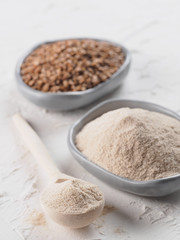 Buckwheat flour and buckwheat on white background