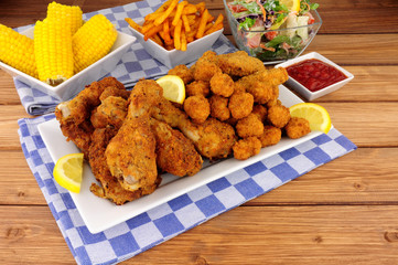 Collection of Southern fried chicken products with sweetcorn and salad