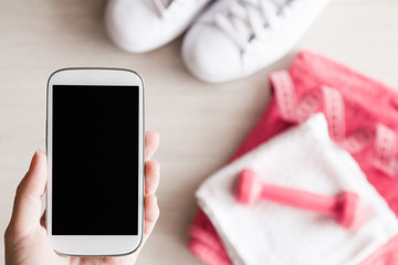 Workout phone on the fitness accessories background. Cares about a body. Sport concept. Top view. Empty place for a text or workout program on the smart phone.