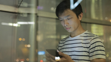 Man using cellphone with window reflection